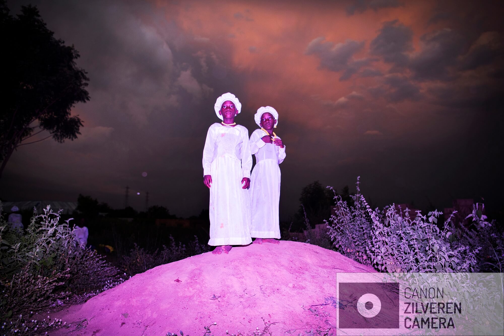 This collaborative photographic project visually investigates the mythology of twin hood and how paradoxical beliefs regarding twins manifest in Nigeria. Using twinhood as a vehicle to explore the friction between the communal and the individual embodied by the twin: two people that are one.

West Africa and specifically Yoruba-land (Nigeria’s South West) has ten times more twins than any other region in the world. Communities have developed cultural practices in response to this high twin birth rate, from veneration to demonisation. In some areas the twin spirit is worshiped and celebrated. In others, twins are vilified, persecuted and killed for their perceived role in bringing bad luck. 

By creating an aesthetic language that is meant to reflect and empower the Yoruba belief that twins are “magical” and ‘supernatural’ they aim to document twin hood in Nigeria in a way that challenges simplistic representation of African traditions.

Images are shot in/around two locations in Nigeria (2018):

Igbo Ora, ‘Twin capital of the world’ where almost each household has twins and twins are seen as a token for good luck, good health and wealth. The first edition of the ‘Twin Festival’ was held in Igbo Ora in Nov. 2018.

An orphanage in Gwagwalada where two missionaries started rescuing newborn children from being killed by their community. When born as twins or when their mother dies during child labor they are seen as an ‘evil’ spirit bringing bad luck.